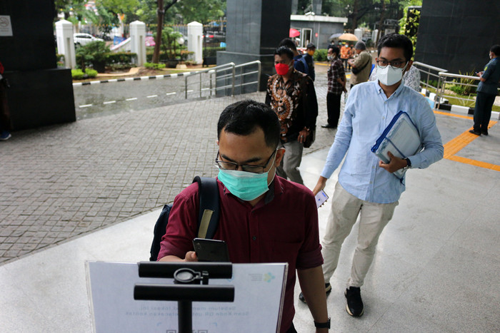Para pengunjung dan pegawai melakukan scan identitas melalui aplikasi PeduliLindungi saat akan memasuki gedung PN Jakarta Pusat, Selasa (19/10/2021).