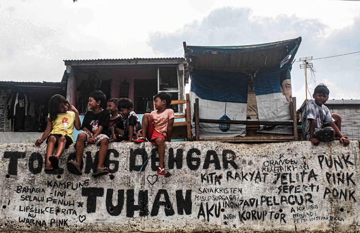 Anak-anak sedang bermain tanpa menggunakan masker di tepi sungai, Jakarta, Selasa (19/10/2021).