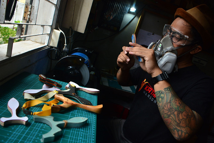 Seorang pengrajin ketapel (slingshot) menyelesaikan pembuatan ketapel di Workshop Depok, Jawa Barat, Rabu (20/10/2021).