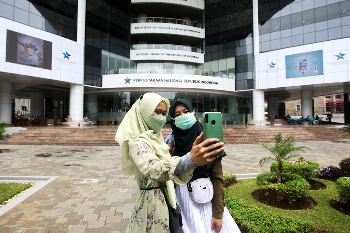 Antrian pengunjung melakukan scan barcode aplikasi PeduliLindungi sebelum masuk ke Perpusnas di Jakarta Pusat, Jumat (22/10/2021).