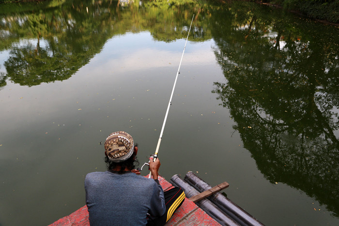 Warga memancing di Danau Taman Kebun Bibit Wonorejo Surabaya, Jawa Timur, Jumat (22/10/2021).