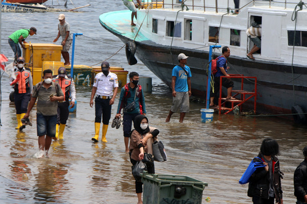 Warga pengguna jasa transportasi ojeg atau perahu tradisional Penyeberangan kepulauan seribu tiba di Pelabuhan Kali Adem Muara Angke, Sabtu (23/10/2021).