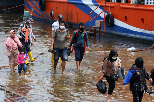 Warga pengguna jasa transportasi ojeg atau perahu tradisional Penyeberangan kepulauan seribu tiba di Pelabuhan Kali Adem Muara Angke, Sabtu (23/10/2021).
