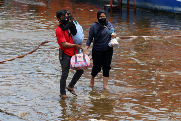 Warga pengguna jasa transportasi ojeg atau perahu tradisional Penyeberangan kepulauan seribu tiba di Pelabuhan Kali Adem Muara Angke, Sabtu (23/10/2021).