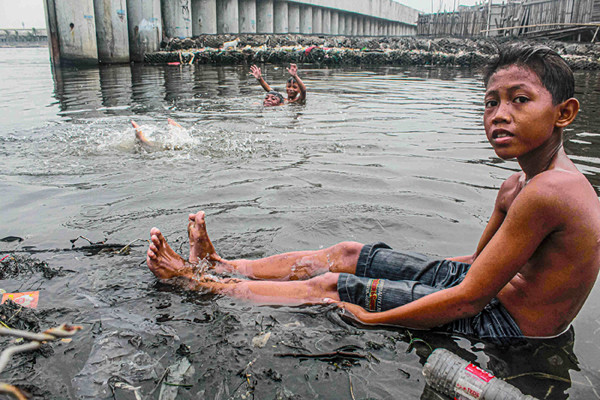 Sejumlah anak-anak sedang bermain di dermaga yang dikelilingi sampah di kawasan Cilincing, Jakarta Utara, Senin (25/10/2021).