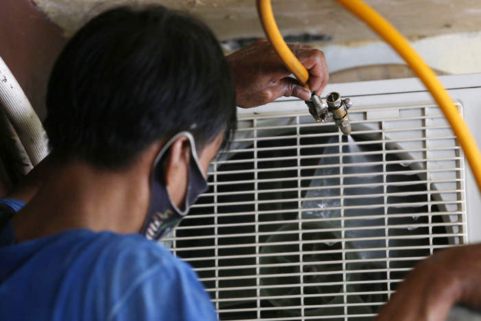 Teknisi membersihkan Air conditioner (AC) disalah satu rumah pelanggan di Surabaya, Jawa Timur, Senin (25/10/2021).