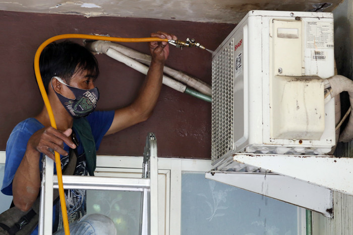 Teknisi membersihkan Air conditioner (AC) disalah satu rumah pelanggan di Surabaya, Jawa Timur, Senin (25/10/2021).