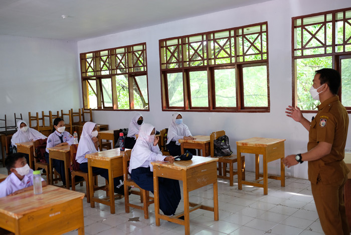 Sejumlah siswa siswi masuk belajar secara tatap muka di SMP Negeri 36 Makassar, Senin (25/10/2021).