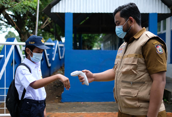 Sejumlah siswa siswi masuk belajar secara tatap muka di SMP Negeri 36 Makassar, Senin (25/10/2021).
