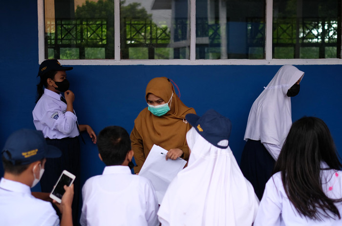 Sejumlah siswa siswi masuk belajar secara tatap muka di SMP Negeri 36 Makassar, Senin (25/10/2021).