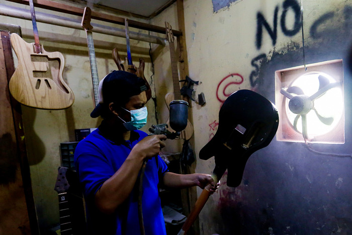 Pekerja menyelesaikan pembuatan gitar listrik Syukey Instrumen di kawasan Ciputat Timur, Tangerang Selatan, Banten, Selasa (26/10/2021).