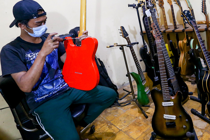 Pekerja menyelesaikan pembuatan gitar listrik Syukey Instrumen di kawasan Ciputat Timur, Tangerang Selatan, Banten, Selasa (26/10/2021).