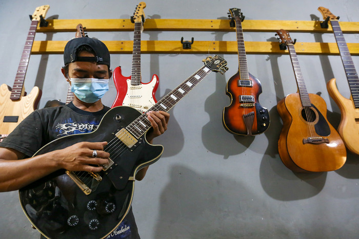 Pekerja menyelesaikan pembuatan gitar listrik Syukey Instrumen di kawasan Ciputat Timur, Tangerang Selatan, Banten, Selasa (26/10/2021).
