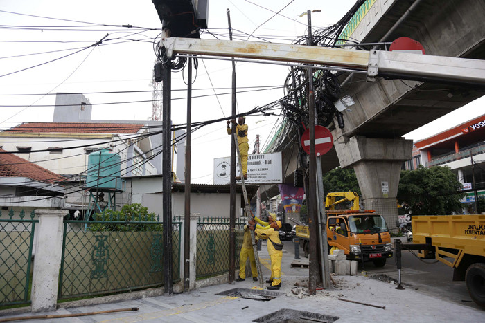 Petugas Dinas Bina Marga DKI Jakarta menata instalasi kabel yang semrawut di kawasan Wolter Monginsidi, Jakarta Selatan, Rabu, (27/10/2021).