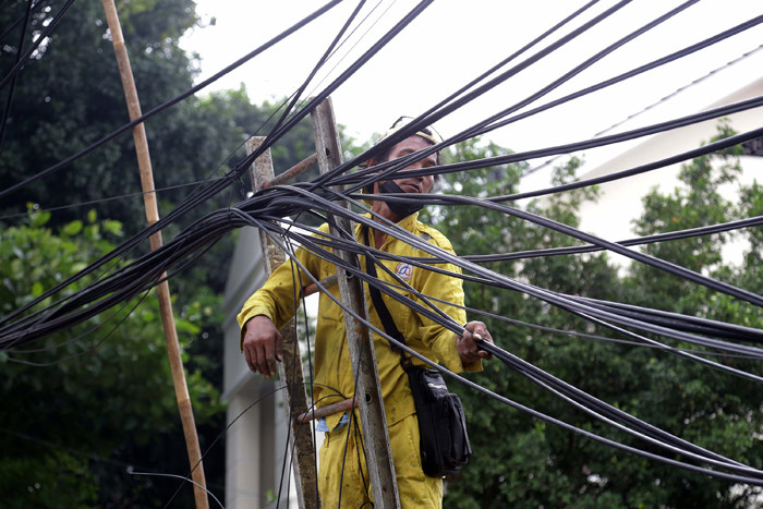 Petugas Dinas Bina Marga DKI Jakarta menata instalasi kabel yang semrawut di kawasan Wolter Monginsidi, Jakarta Selatan, Rabu, (27/10/2021).