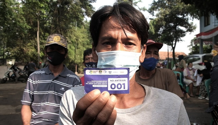 Warga mendapatkan suntikan vaksin pertama di Sentra Vaksinasi Covid-19 bagi Komunitas Pemulung dan Pengepul di TPA Sumur Batu, Bekasi, Rabu (27/10/2021).