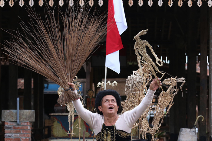 Seniman Meimura memerankan Besut Rusmini ketika memainkan wayang suket bertema Pemuda Adalah Hati dan Pikiran Rakyat di Surabaya, Jawa Timur, Rabu (27/10/2021).