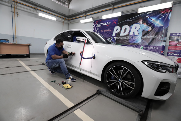 Pekerja sedang melakukan pengecatan bodi disela acara peresmian Autoglad di Pekayon, Kota Bekasi, Jawa Barat, Kamis (28/10/2021).