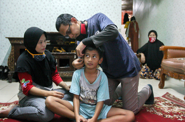 Relawan MNC Peduli memasangkan alat bantu dengar (ABD) untuk Fadli (9) yang mengalami gangguan pendengaran di Kebon Pala, Jakarta Timur, Jumat (29/10/2021).