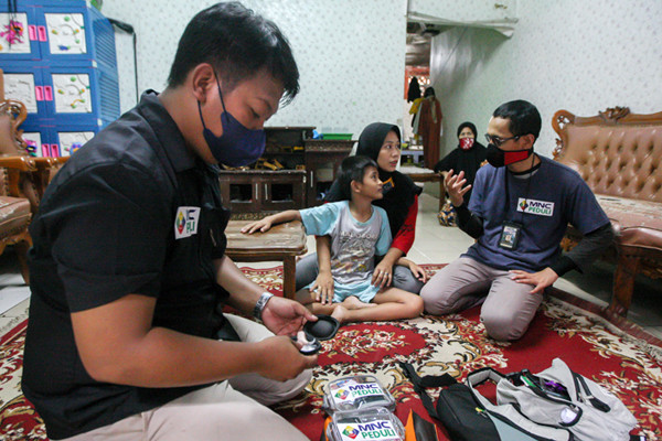 Relawan MNC Peduli memasangkan alat bantu dengar (ABD) untuk Fadli (9) yang mengalami gangguan pendengaran di Kebon Pala, Jakarta Timur, Jumat (29/10/2021).