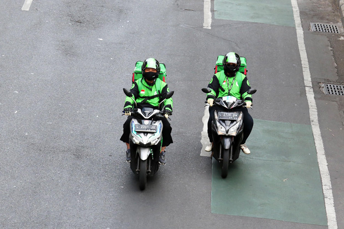 Mitra driver ojek oline (Ojol) GoSend melintas di jalanan kota Surabaya, Jawa Timur, Sabtu (30/10/2021).