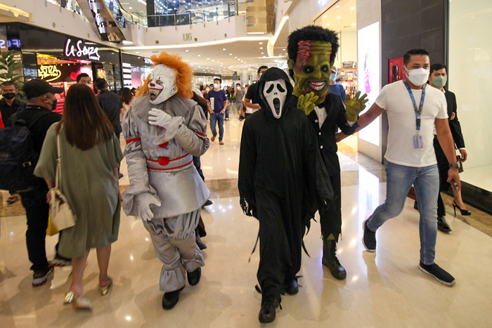 Orang berkostum Halloween berkeliling dan berfoto bersama para pengunjung di Mall Central Park, Jakarta, Minggu (31/10/2021).
