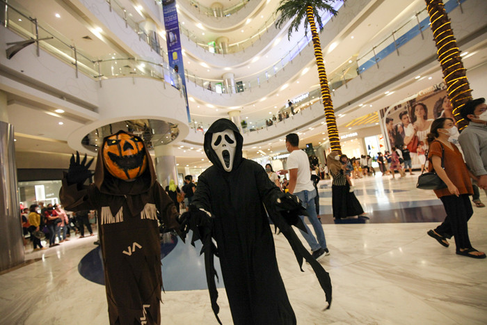 Orang berkostum Halloween berkeliling dan berfoto bersama para pengunjung di Mall Central Park, Jakarta, Minggu (31/10/2021).