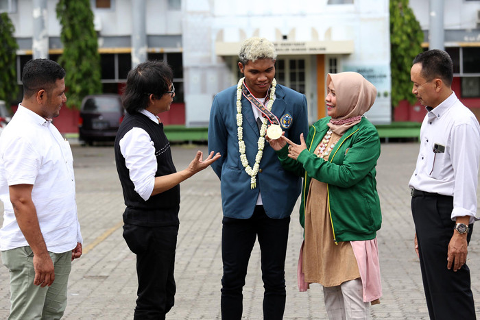 Geraldo Yehezkiel Selanno (tengah), peraih medali emas Cabang Olahraga Atletik Estafet 4 x 100 m Pekan Olahraga Nasional (PON) XX Papua 2021.