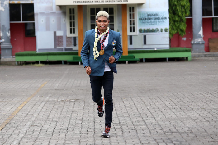 Geraldo Yehezkiel Selanno (tengah), peraih medali emas Cabang Olahraga Atletik Estafet 4 x 100 m Pekan Olahraga Nasional (PON) XX Papua 2021.