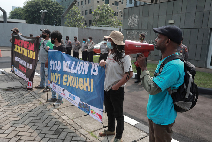 Aktivis melakukan aksi protes ketidakadilan iklim dengan membawa spanduk di depan Kedutaan Besar Inggris, Jakarta, Rabu (3/11/2021).