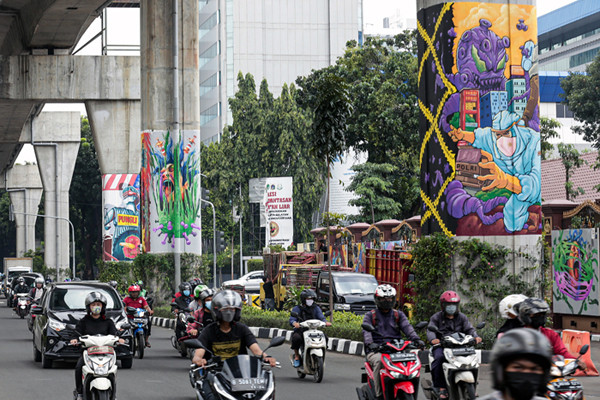 Kendaraan melintas di dekat tiang Jalan Layang Non Tol Transjakarta yang dihiasi mural di kawasan lapangan Bhayangkara, Mabes Polri, Jakarta, Rabu (3/11/2021).