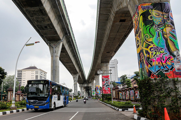 Kendaraan melintas di dekat tiang Jalan Layang Non Tol Transjakarta yang dihiasi mural di kawasan lapangan Bhayangkara, Mabes Polri, Jakarta, Rabu (3/11/2021).