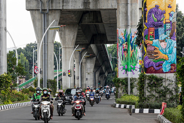 Kendaraan melintas di dekat tiang Jalan Layang Non Tol Transjakarta yang dihiasi mural di kawasan lapangan Bhayangkara, Mabes Polri, Jakarta, Rabu (3/11/2021).