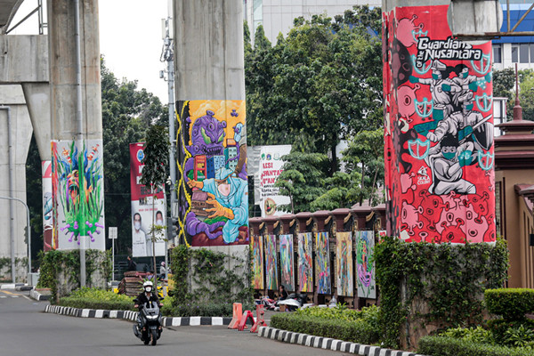 Kendaraan melintas di dekat tiang Jalan Layang Non Tol Transjakarta yang dihiasi mural di kawasan lapangan Bhayangkara, Mabes Polri, Jakarta, Rabu (3/11/2021).