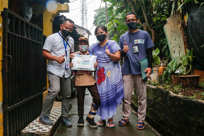 Rizki (9) dibantu ibunya Euis Paridah (40) saat mengenakan sepatu khusus di kediamannya di kawasan Menteng Dalam, Jakarta Selatan, Jumat (5/11/2021).