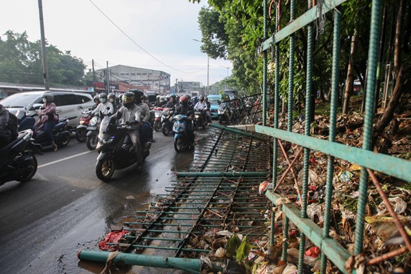 Polisi mengatur lalu lintas dekat tanggul Kali Baru yang jebol akibat luapan air di kawasan Hek, Kramat Jati, Jakarta Timur, Senin (8/11/2021).