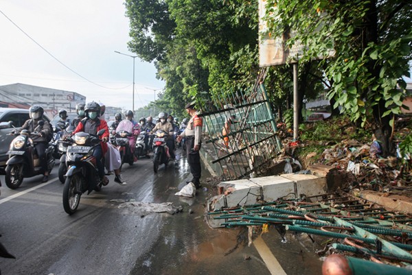 Polisi mengatur lalu lintas dekat tanggul Kali Baru yang jebol akibat luapan air di kawasan Hek, Kramat Jati, Jakarta Timur, Senin (8/11/2021).