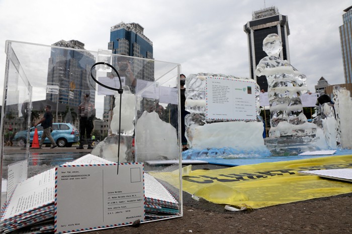 Relawan Greenpeace saat menggelar aksi 1.000 kartu pos rakyat untuk Presiden Joko Widodo di kawasan Patung Kuda, Jakarta Pusat, Rabu (10/11/2021).
