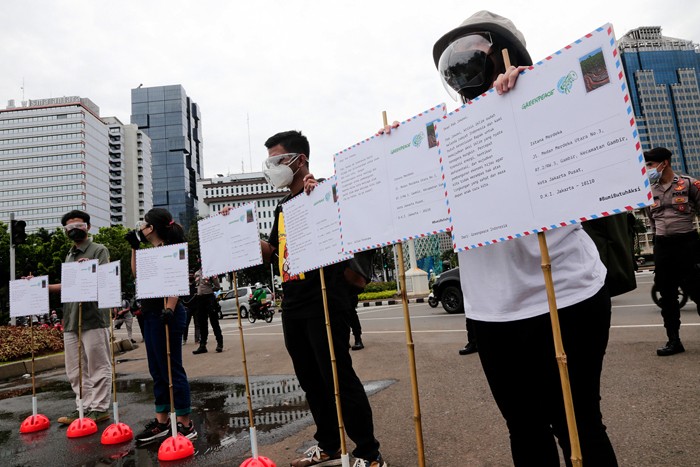 Relawan Greenpeace saat menggelar aksi 1.000 kartu pos rakyat untuk Presiden Joko Widodo di kawasan Patung Kuda, Jakarta Pusat, Rabu (10/11/2021).