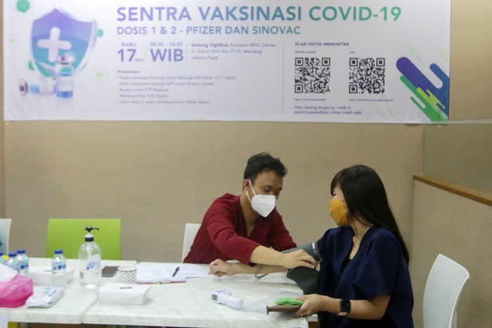 Vaksinator menyuntikkan vaksin Covid-19 kepada warga di sentra vaksinasi MNC Peduli di Gedung HighEnd, MNC Center, Jakarta Pusat, Rabu (17/11/2021).