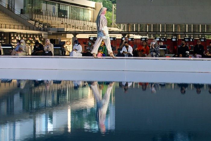 Model memperagakan busana muslim dalam acara Embracing Jakarta Muslim Fashion Week di Aquatic Center, Gelora Bung Karno, Senayan, Jakarta, Kamis (18/11/2021).