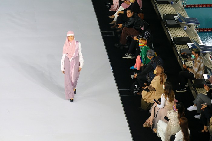 Model memperagakan busana muslim dalam acara Embracing Jakarta Muslim Fashion Week di Aquatic Center, Gelora Bung Karno, Senayan, Jakarta, Kamis (18/11/2021).