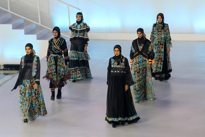 Model memperagakan busana muslim dalam acara Embracing Jakarta Muslim Fashion Week di Aquatic Center, Gelora Bung Karno, Senayan, Jakarta, Kamis (18/11/2021).