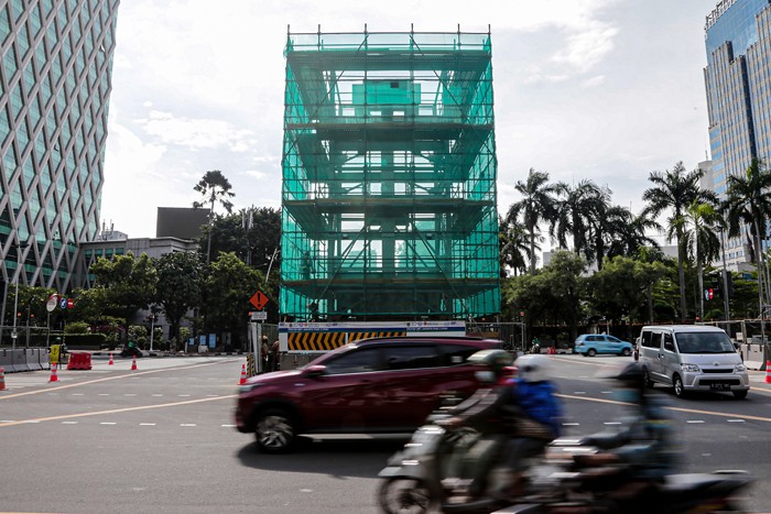 Kendaraan melintas di dekat proyek relokasi Tugu Jam di Jalan M.H Thamrin, Jakarta Pusat, Senin (22/11/2021).
