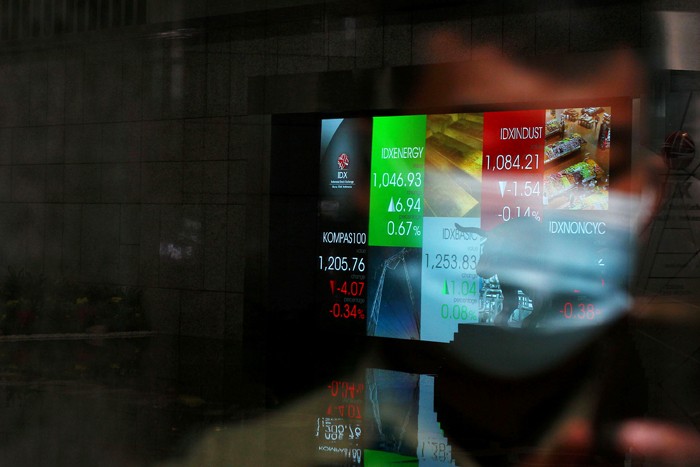 Karyawan membersihkan replika Patung Banteng Wulung didepan layar Indeks Harga Saham Gabungan (IHSG) di PT Bursa Efek Indonesia, Jakarta, Selasa (23/11/2021).