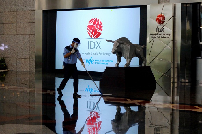 Karyawan membersihkan replika Patung Banteng Wulung didepan layar Indeks Harga Saham Gabungan (IHSG) di PT Bursa Efek Indonesia, Jakarta, Selasa (23/11/2021).