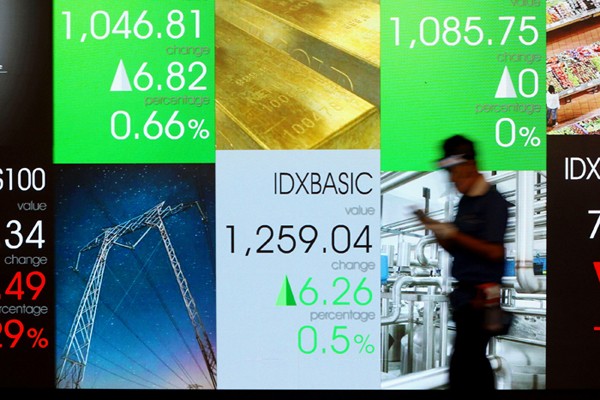 Karyawan membersihkan replika Patung Banteng Wulung didepan layar Indeks Harga Saham Gabungan (IHSG) di PT Bursa Efek Indonesia, Jakarta, Selasa (23/11/2021).