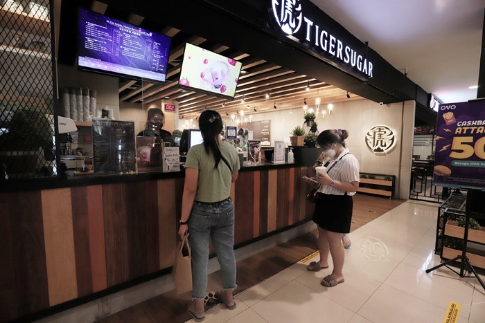 Karyawan merapikan menu makanan di salah satu cafe di Jakarta, Selasa (23/11/2021).