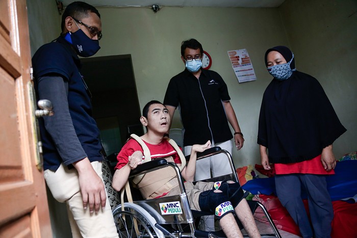 Head of CSR MNC Group Tengku Havid (kiri) berbincang dengan Daronah yang merupakan orang tua dari Slamet (21) saat penyerahan bantuan dari MNC Peduli.