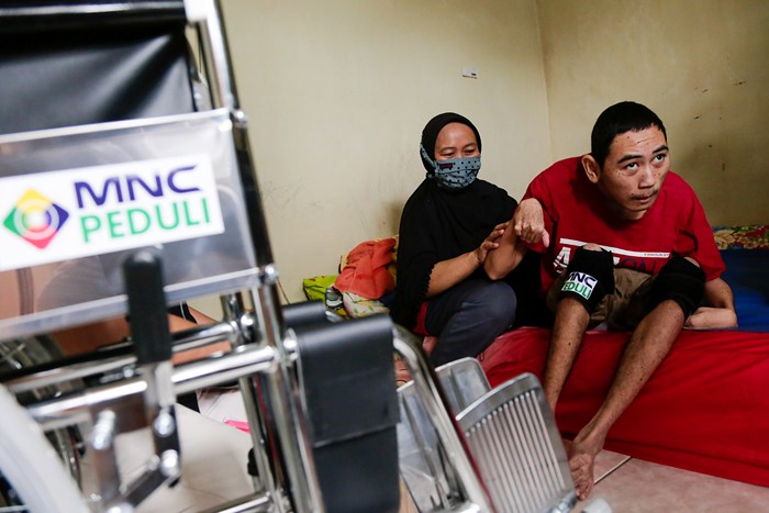 Head of CSR MNC Group Tengku Havid (kiri) berbincang dengan Daronah yang merupakan orang tua dari Slamet (21) saat penyerahan bantuan dari MNC Peduli.